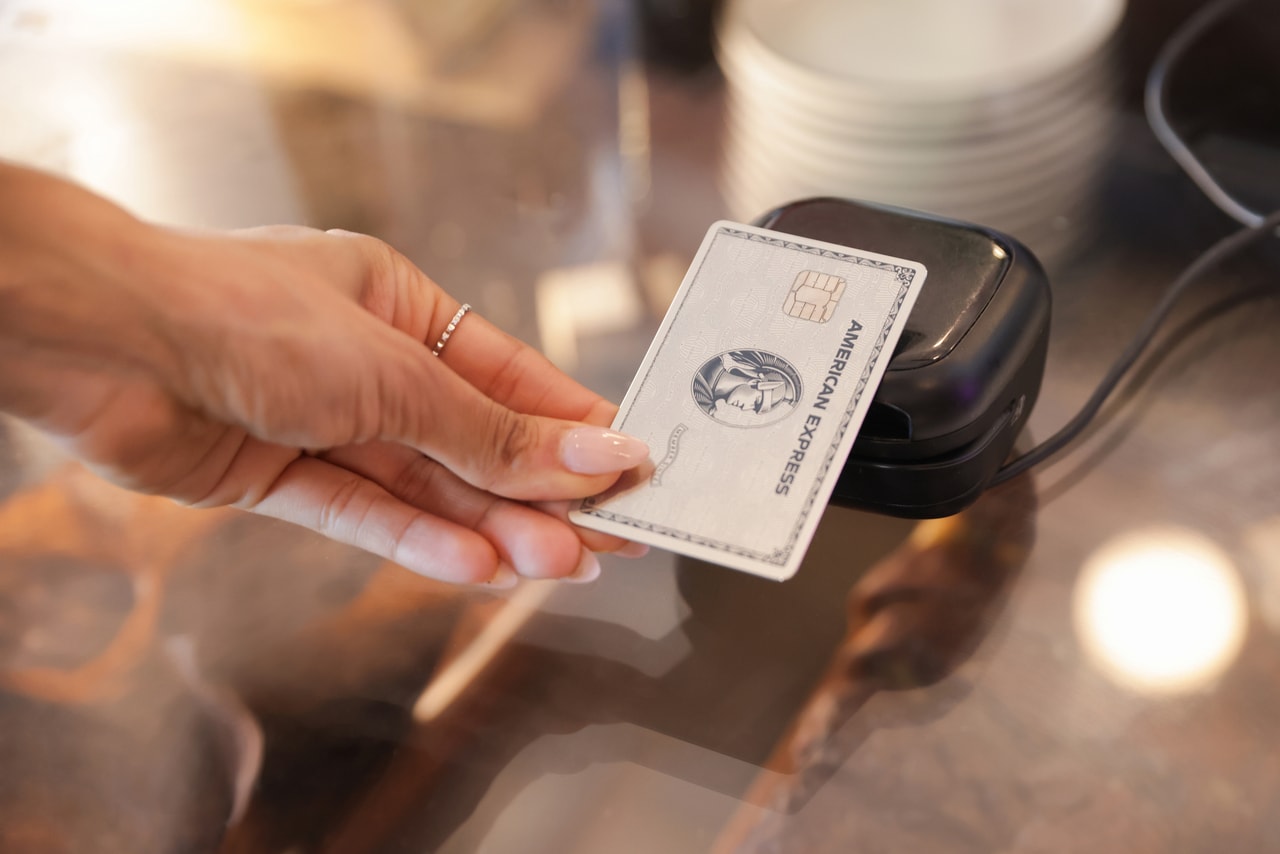 Eine Person hält eine Kreditkarte über ein mobiles Zahlungsgerät