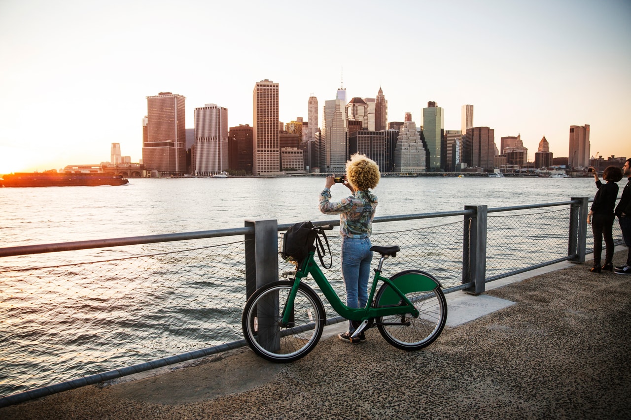 Eine Frau schaut auf die Stadt von einem Fahrrad aus.
