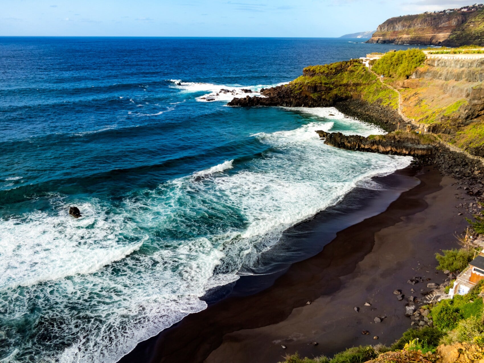 Aufsicht einer menschenleeren Strandbucht mit schwarzem Vulkansand Aufsicht einer menschenleeren Strandbucht mit schwarzem Vulkansand