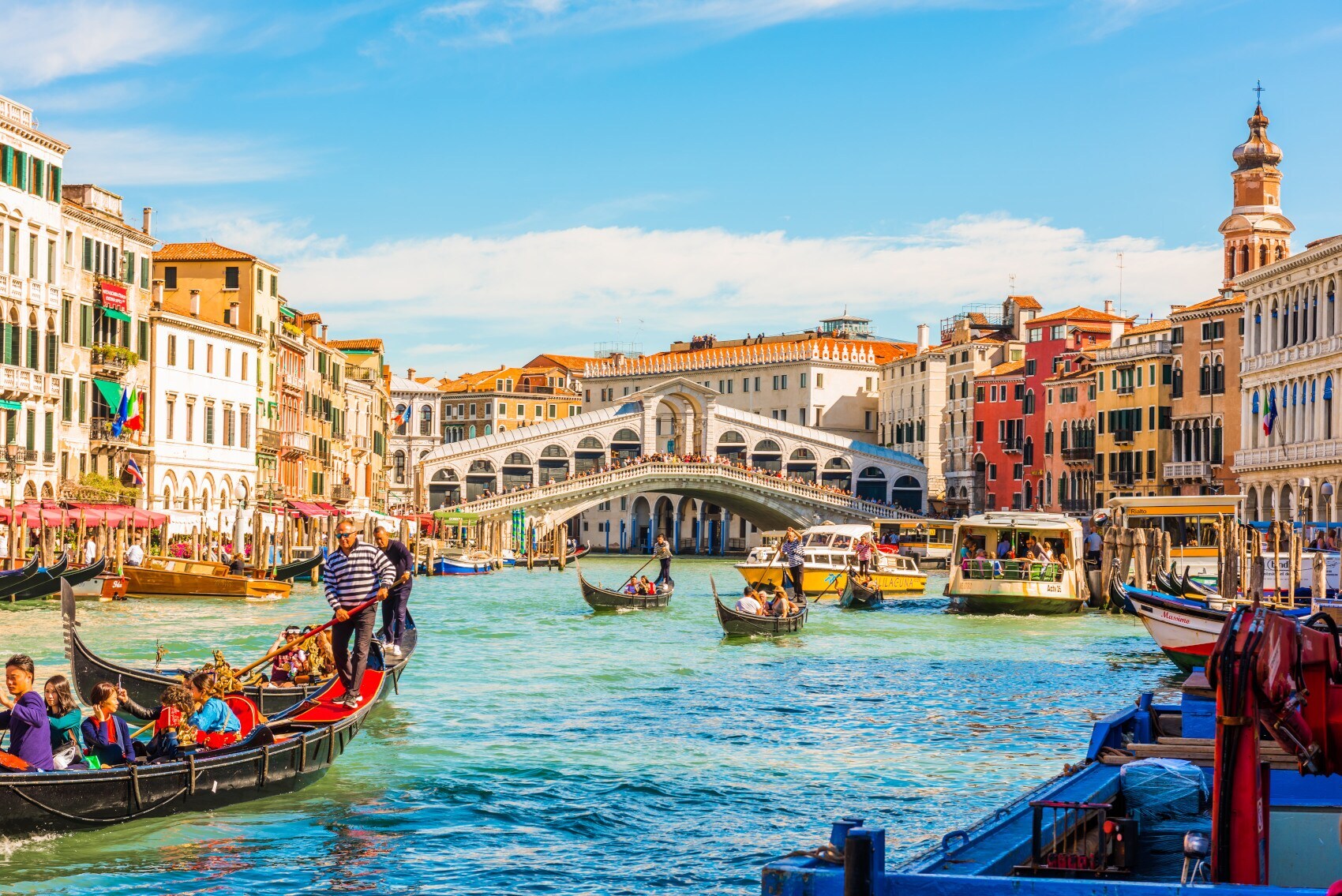 Blick auf die Rialtobrücke über den Canal Grande in Venedig, im Vordergrund mehrere Gondeln