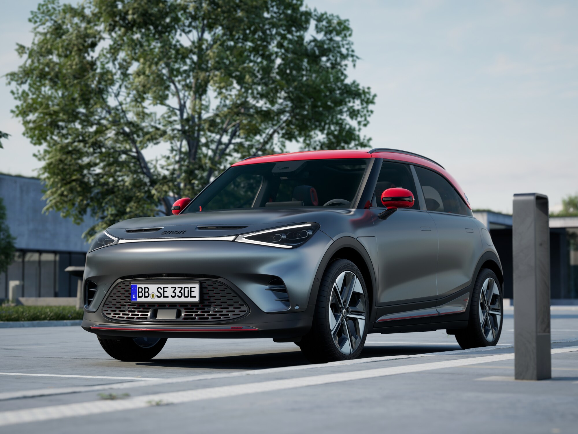 Ein anthrazitfarbener smart #1 BRABUS mit rotem Dach steht auf einer Straße.