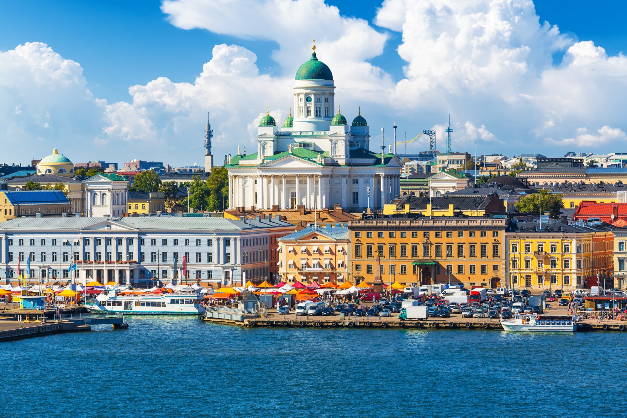 Blick auf eine Stadt am Wasser mit bunten Häusern und einer weißen Kathedrale im Mittelpunkt. Blick auf eine Stadt am Wasser mit bunten Häusern und einer weißen Kathedrale im Mittelpunkt.