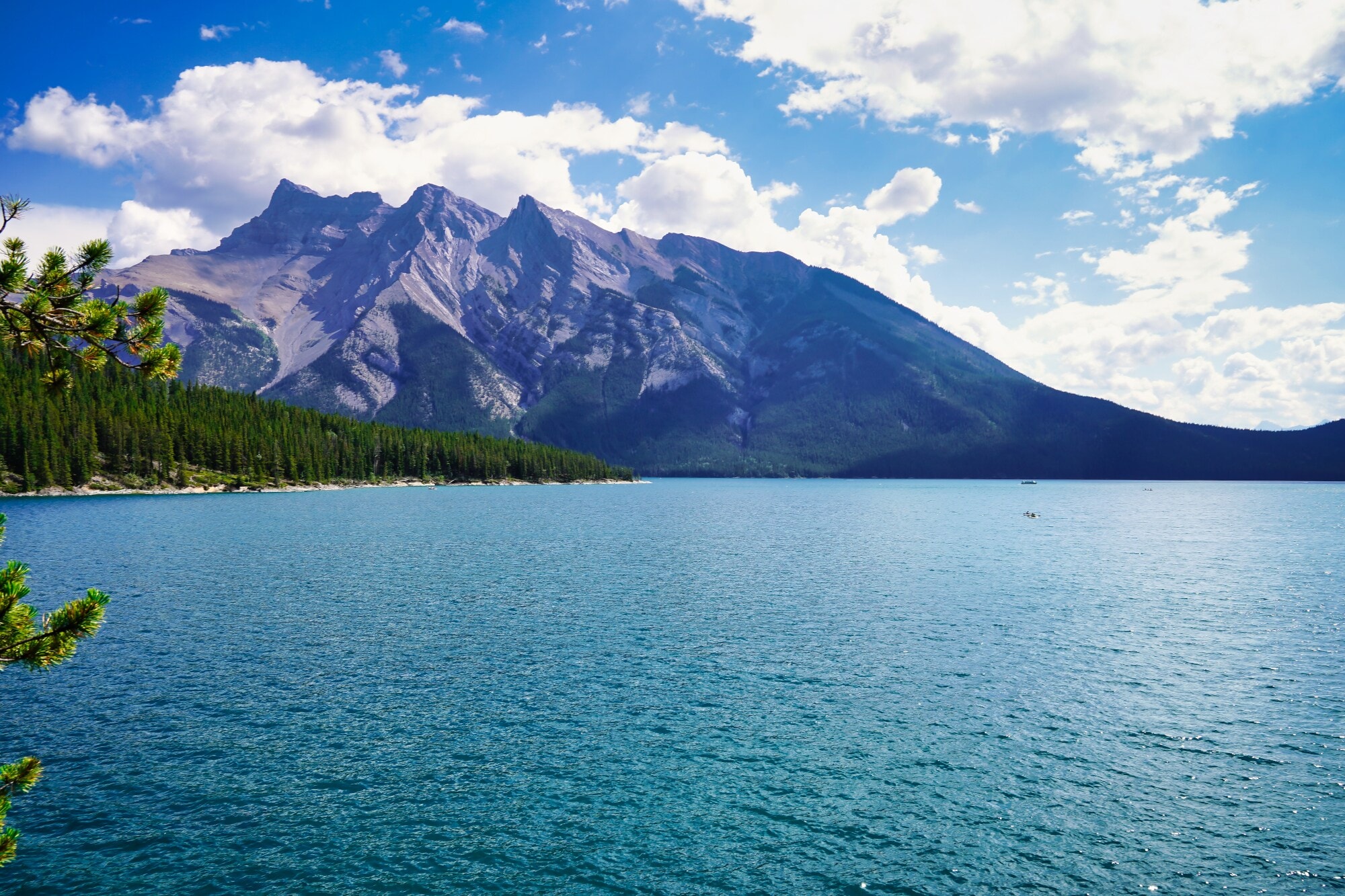 Ein türkisfarbener See vor einem Gebirge und einem kleinen Waldstück. Ein türkisfarbener See vor einem Gebirge und einem kleinen Waldstück.