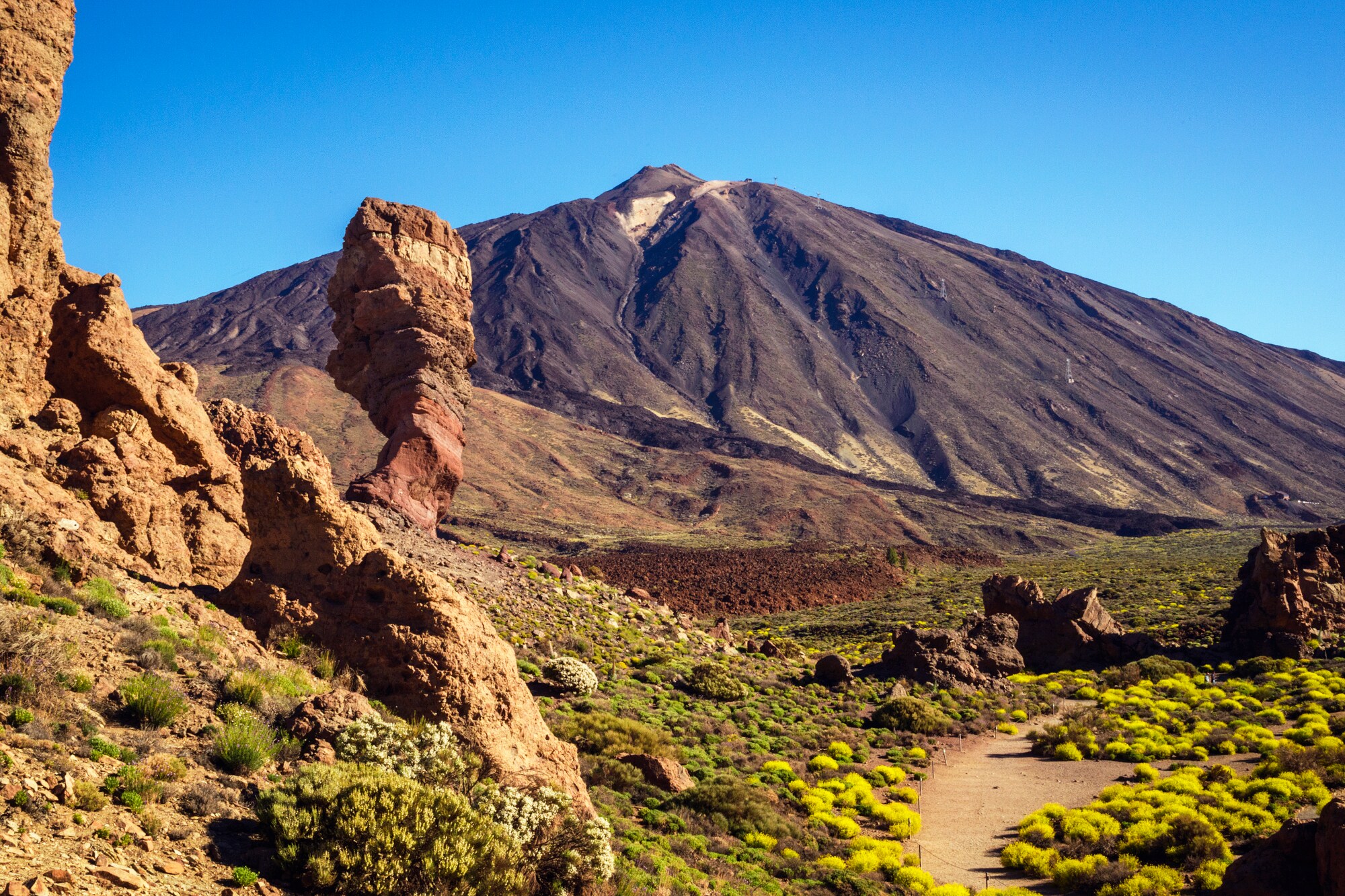 Eine Vulkanlandschaft mit Felsen und einem großen Berg im Hintergrund. Eine Vulkanlandschaft mit Felsen und einem großen Berg im Hintergrund.