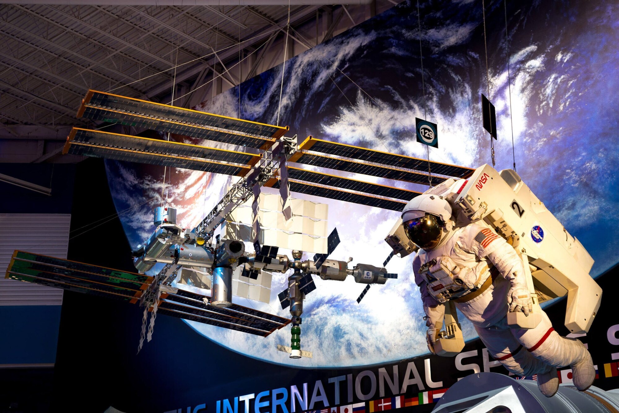 Die International Space Station und ein Astronaut als hängende Modelle in einem Museum.