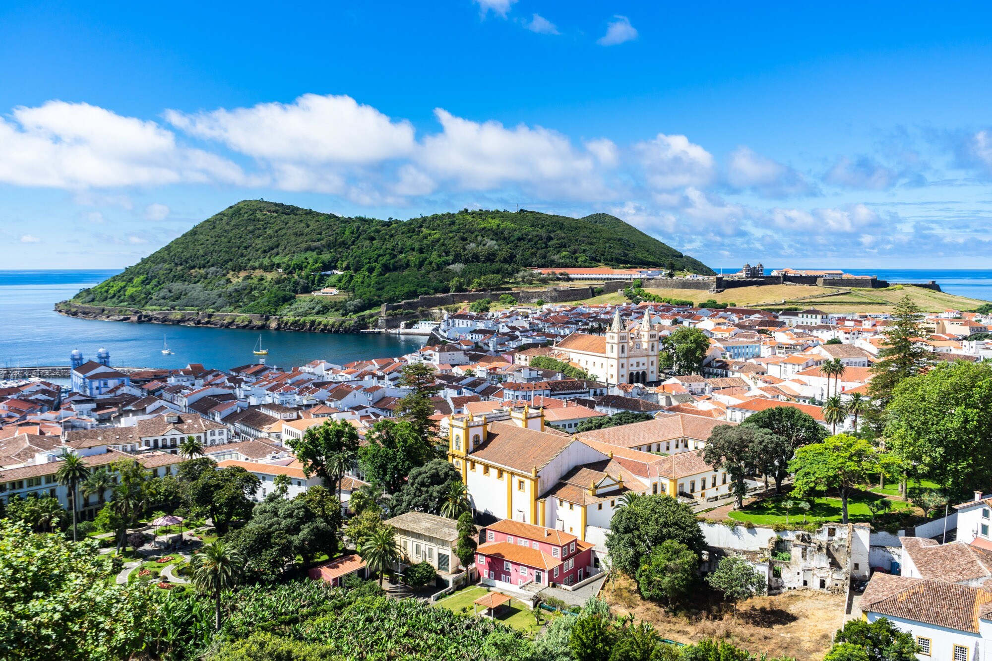 Mediterrane Kleinstadt am Meer, umgeben von grüner Hügellandschaft. Mediterrane Kleinstadt am Meer, umgeben von grüner Hügellandschaft.