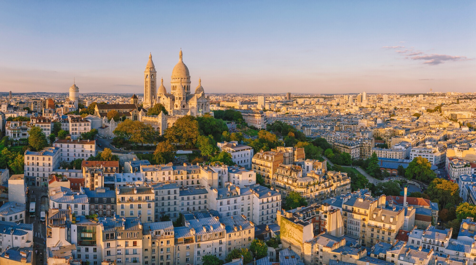 Luftaufnahme des Montmartre-Hügels mit der Basilique du Sacre-Coeur in Paris bei Sonnenuntergang