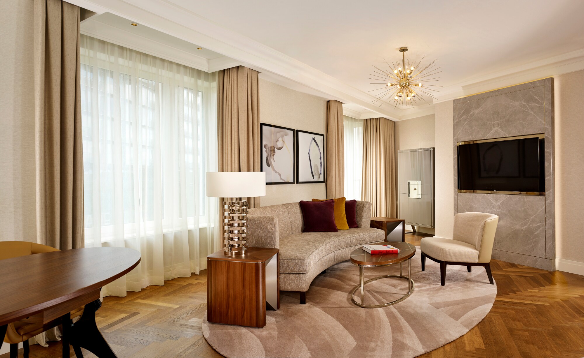 Stilvolle Hotelsuite mit Parkettboden und hellen Polstermöbeln.
