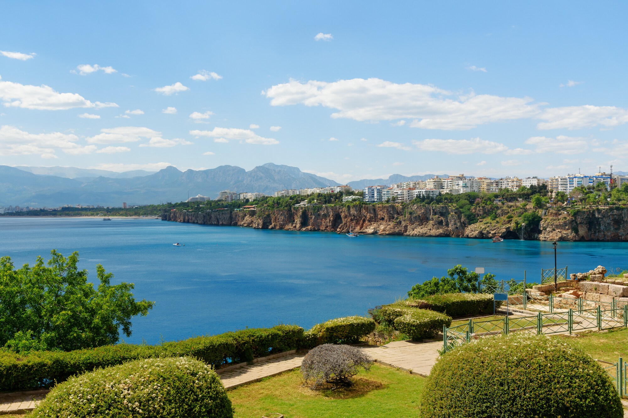 Eine Parkanlage in Antalya. Im Hintergrund liegen das Meer, ein Teil der Stadt und die Berge.