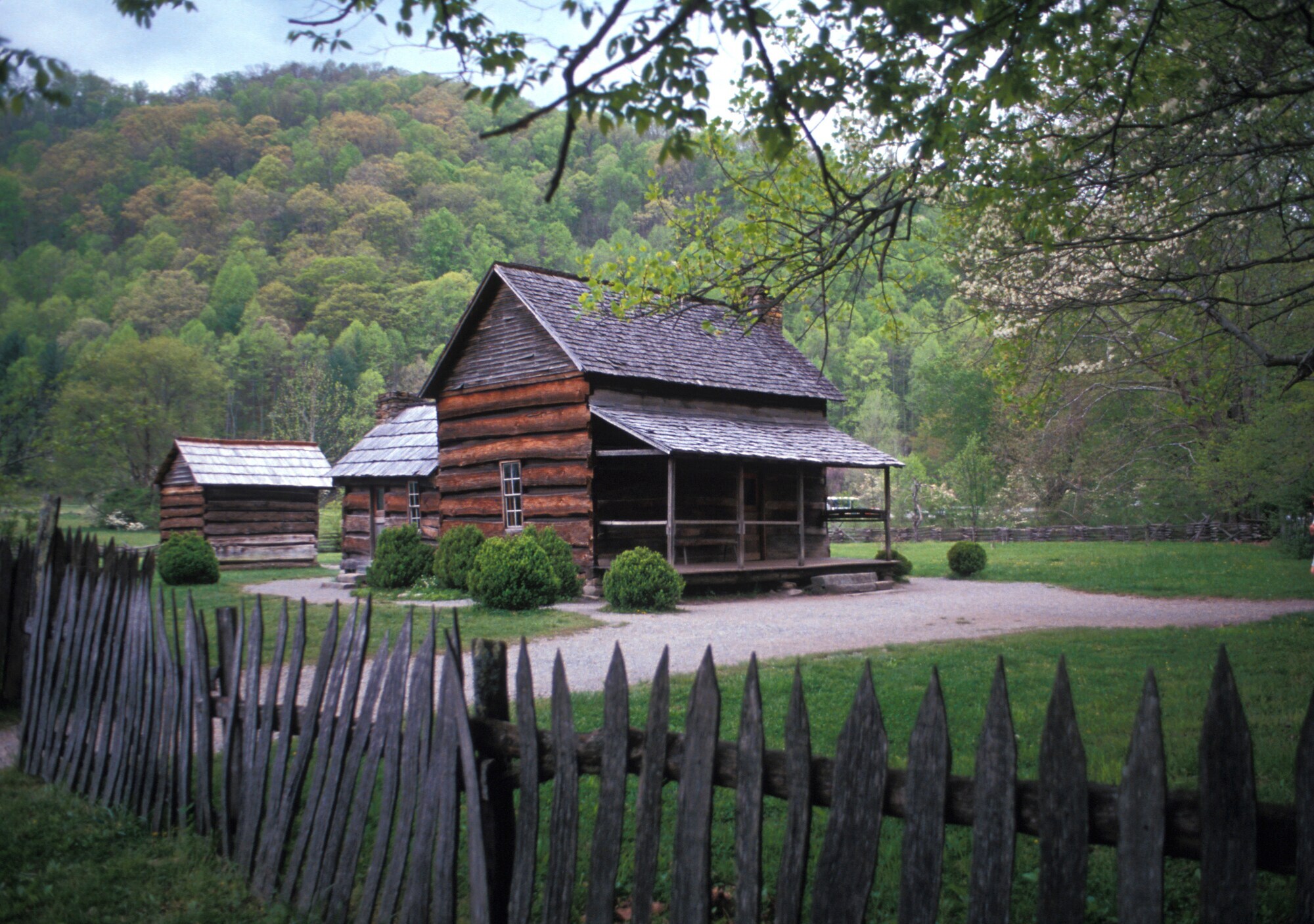 Eine Siedlung mehrerer Blockhütten, die von einem Holzzaun umgeben sind.