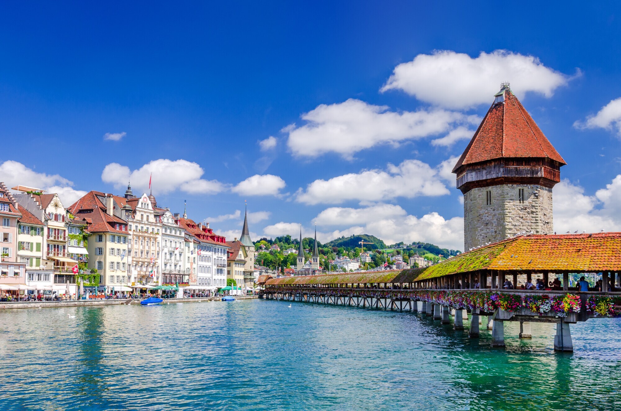 Altstadtpanorama von Luzern am Wasser mit einer hölzernen Brücke vor einem Wasserturm. Altstadtpanorama von Luzern am Wasser mit einer hölzernen Brücke vor einem Wasserturm.