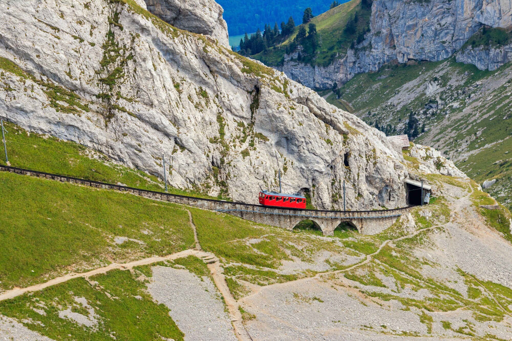 Eine rote Zahnradbahn in karger Berglandschaft.