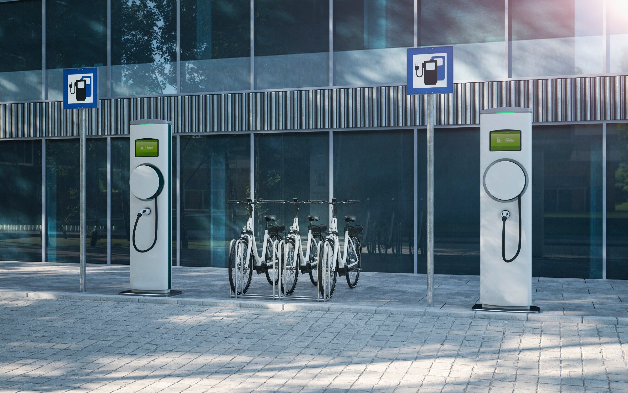 Eine Ladestation für E-Bikes vor einem Bürogebäude mit Glasfassade.