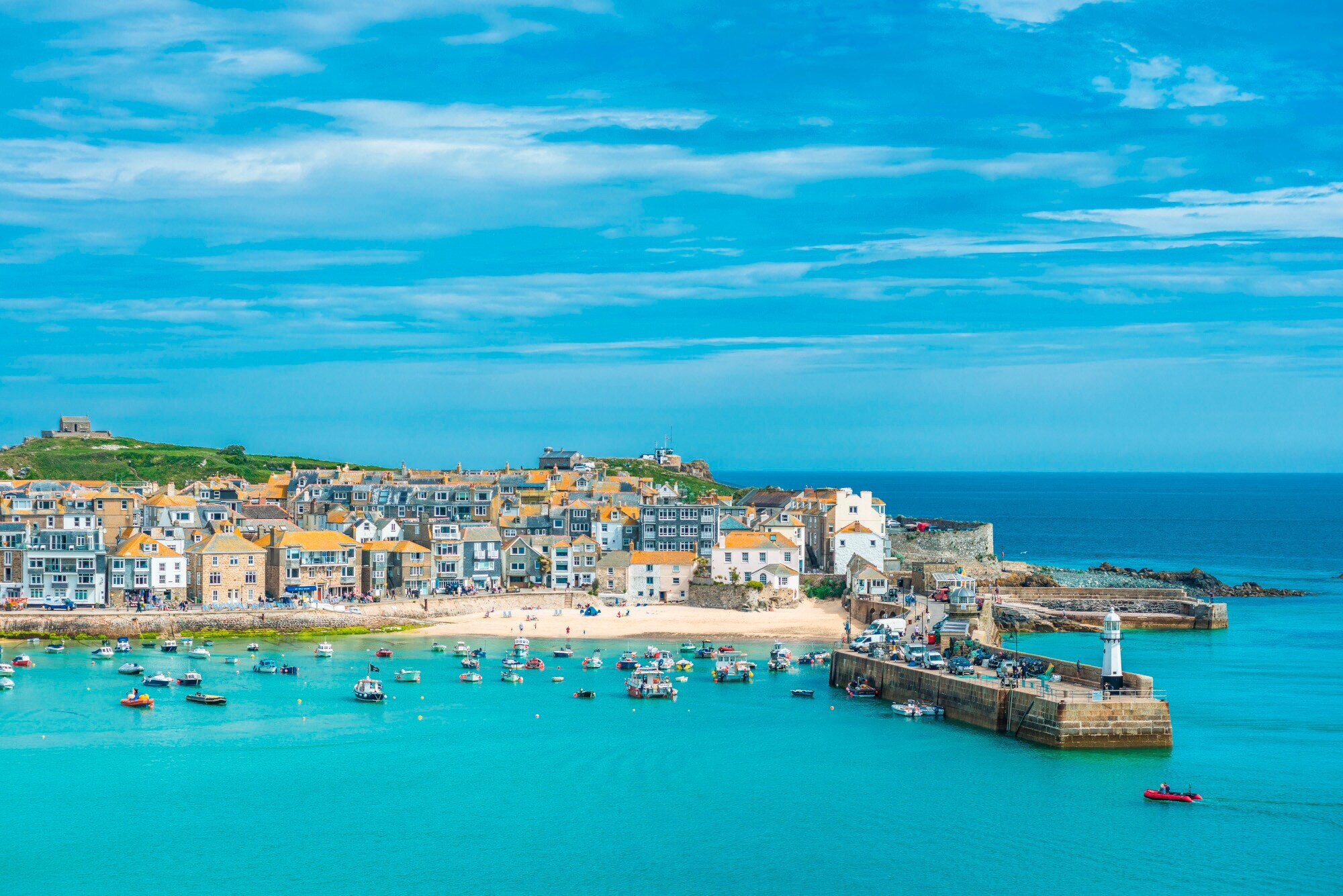 Kleiner Fischerort mit Sandstrand am türkisblauen Meer.