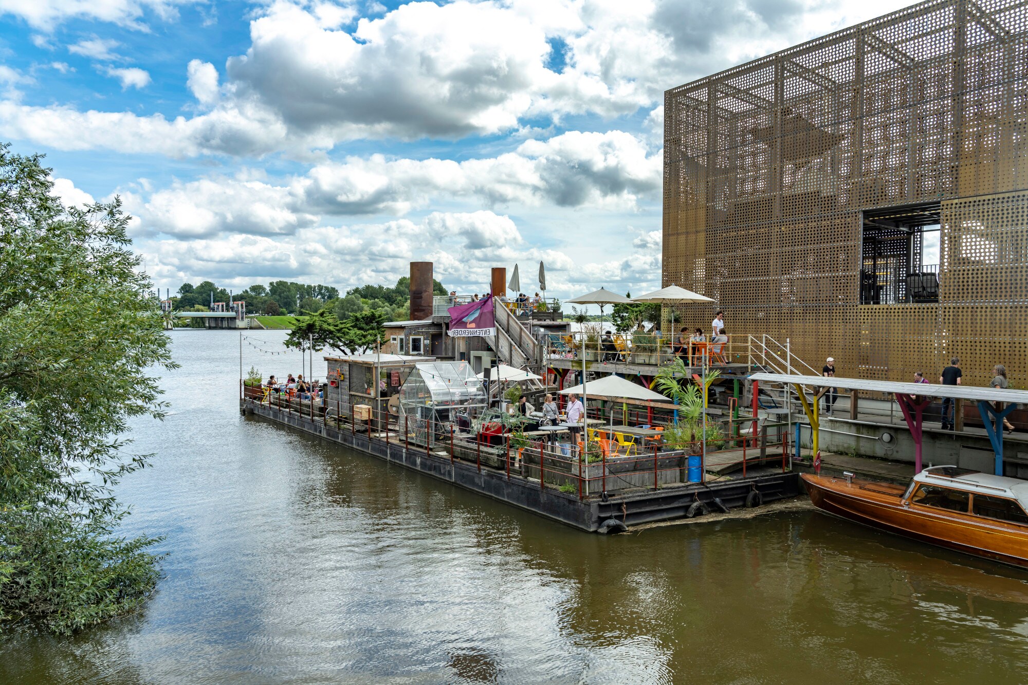 Ein Außencafé neben einem goldenen Pavillon auf einem Ponton. Ein Außencafé neben einem goldenen Pavillon auf einem Ponton.