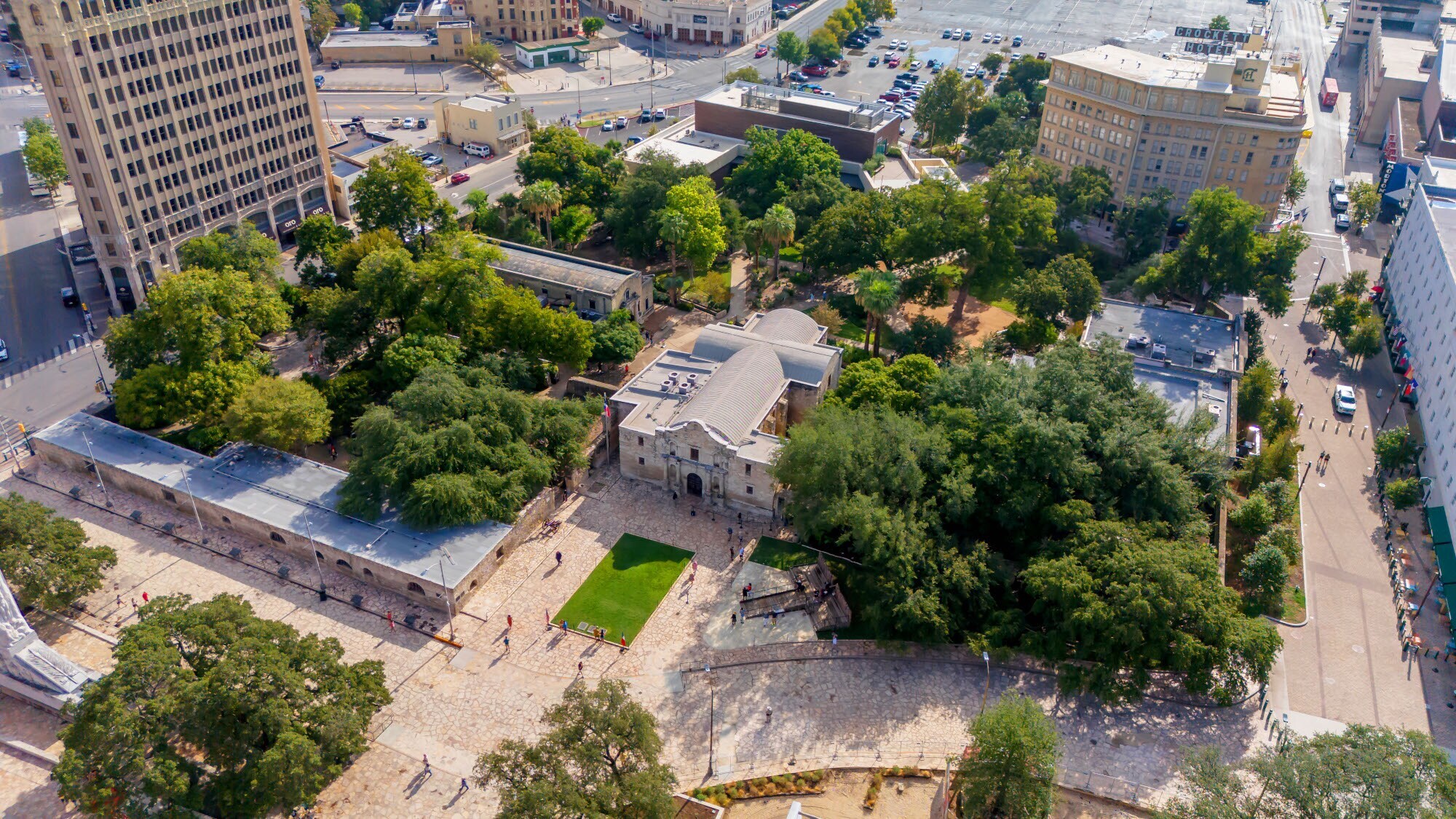 Gebäudekomplex der Missionsstätte The Alamo mit Kirche und Garten im Stadtzentrum aus der Luftperspektive.