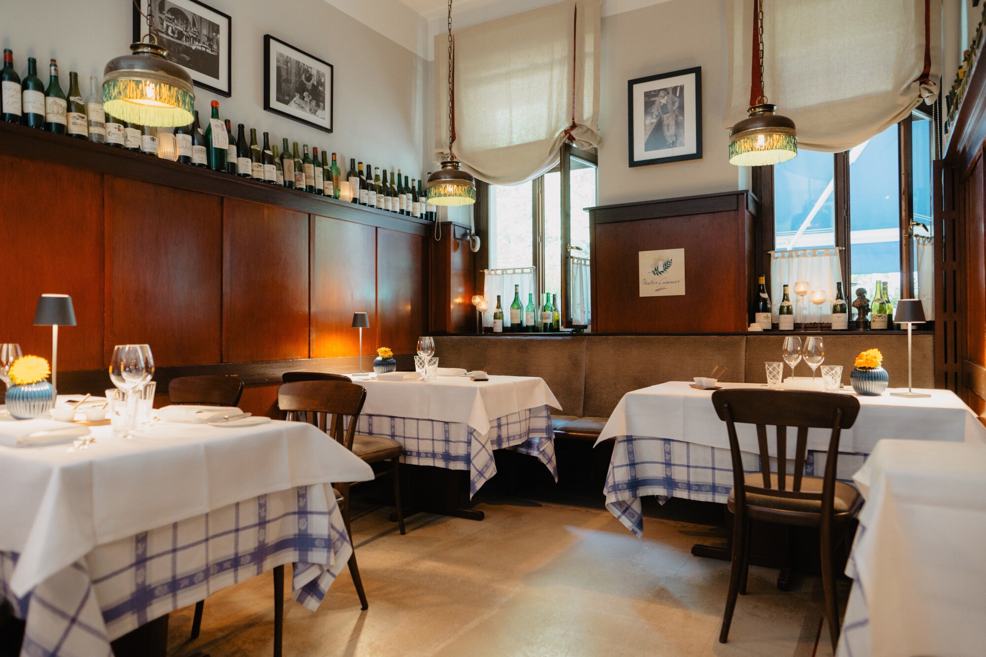 Gemütlicher Speiseraum mit Holzverkleidung und eingedeckten Tischen in einer Brasserie.