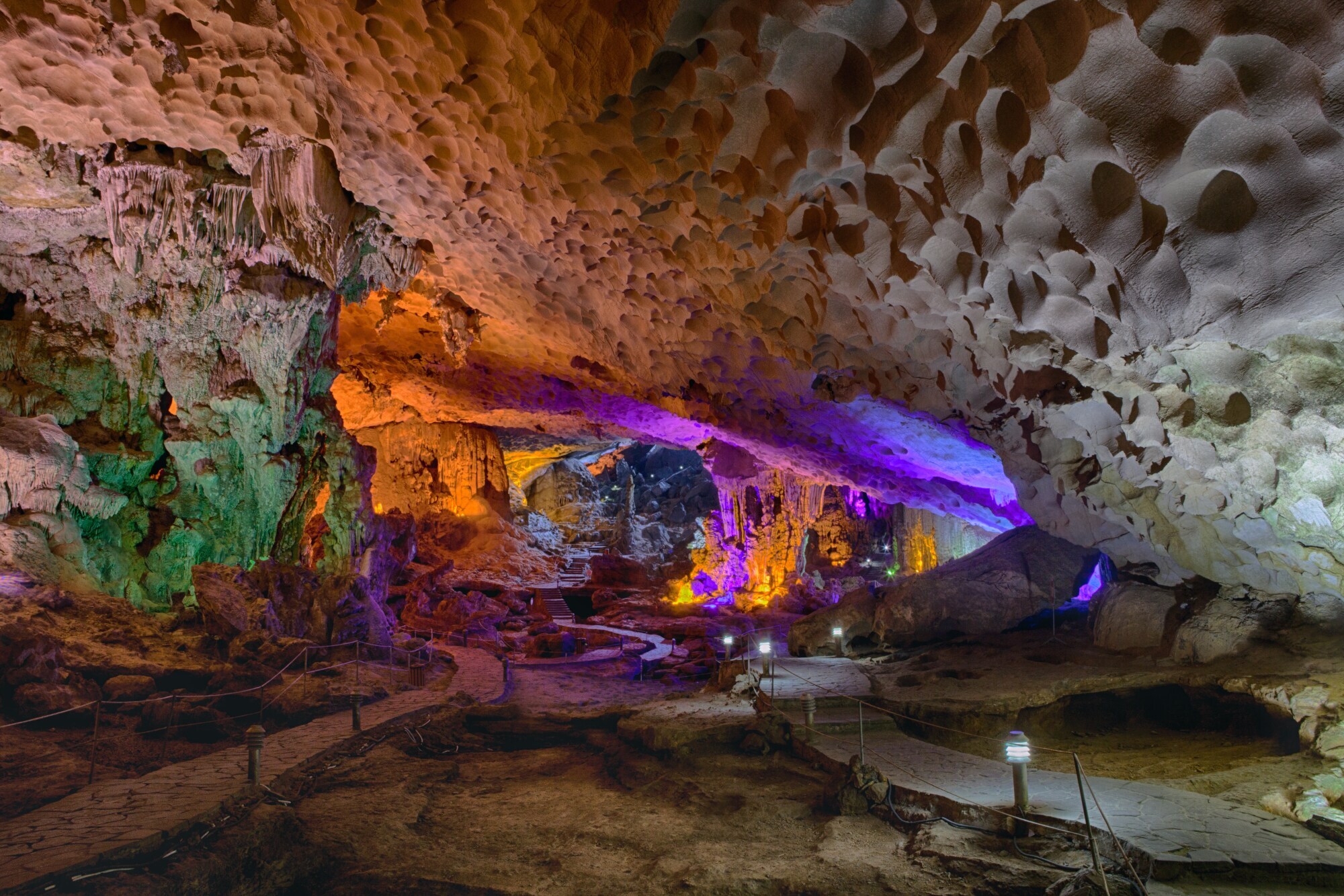 Eine in verschiedenen Farben beleuchtete Tropfsteinhöhle.