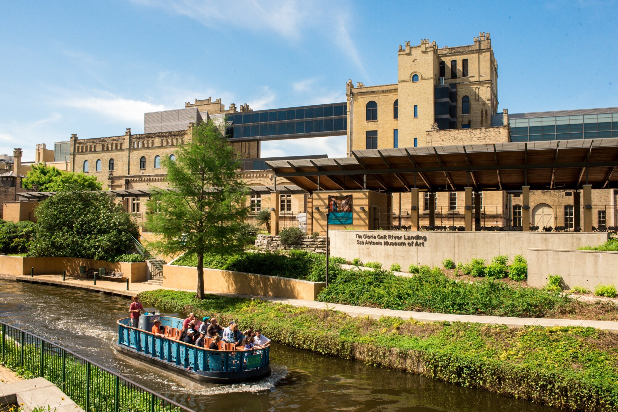 Ein Ausflugsboot auf einem schmalen Fluss vor einem modernen Museum in einem historischen Brauereigebäude. Ein Ausflugsboot auf einem schmalen Fluss vor einem modernen Museum in einem historischen Brauereigebäude.