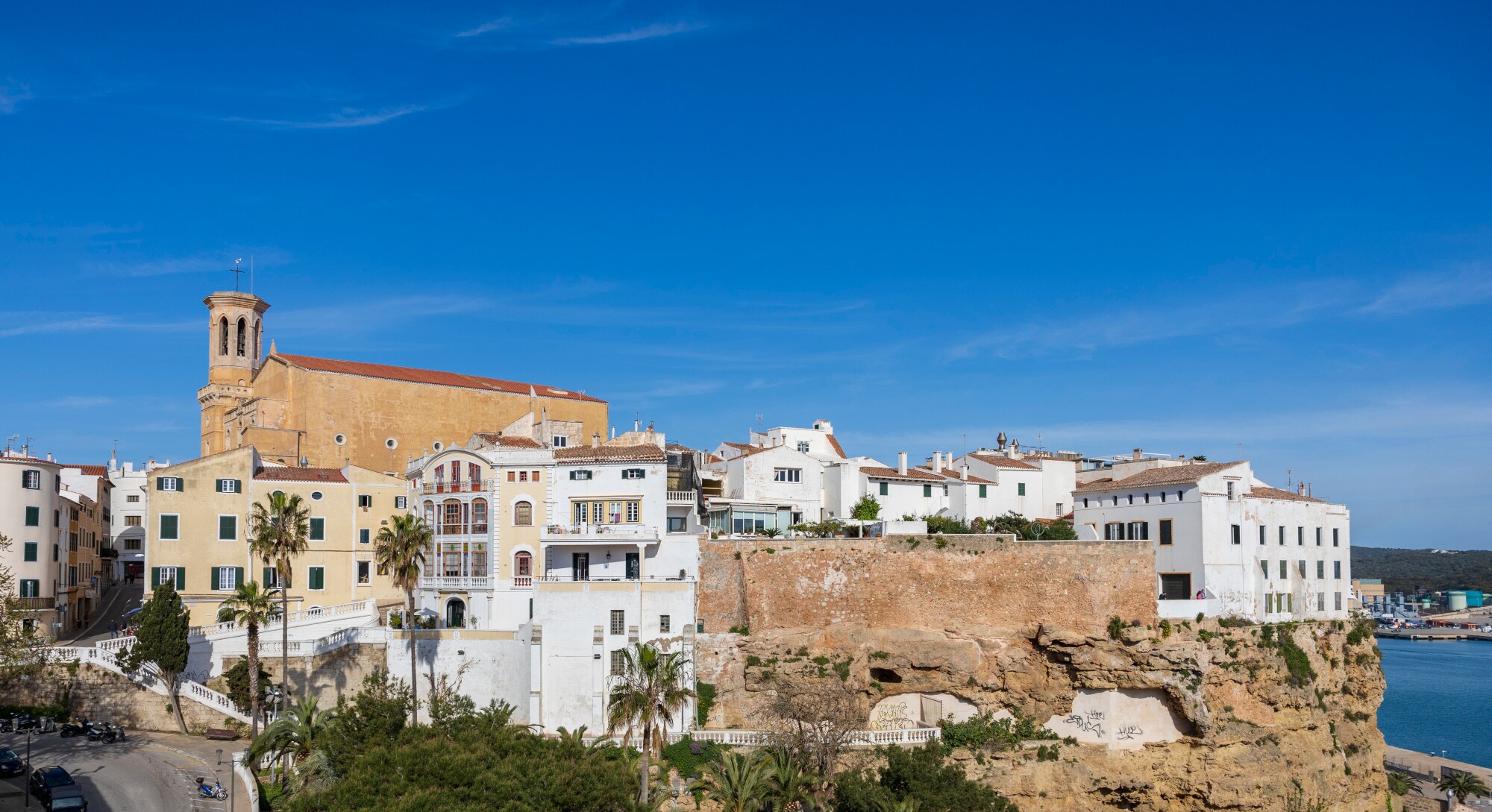 Häuser auf einer Anhöhe mit einer Kirche im Hintergrund.