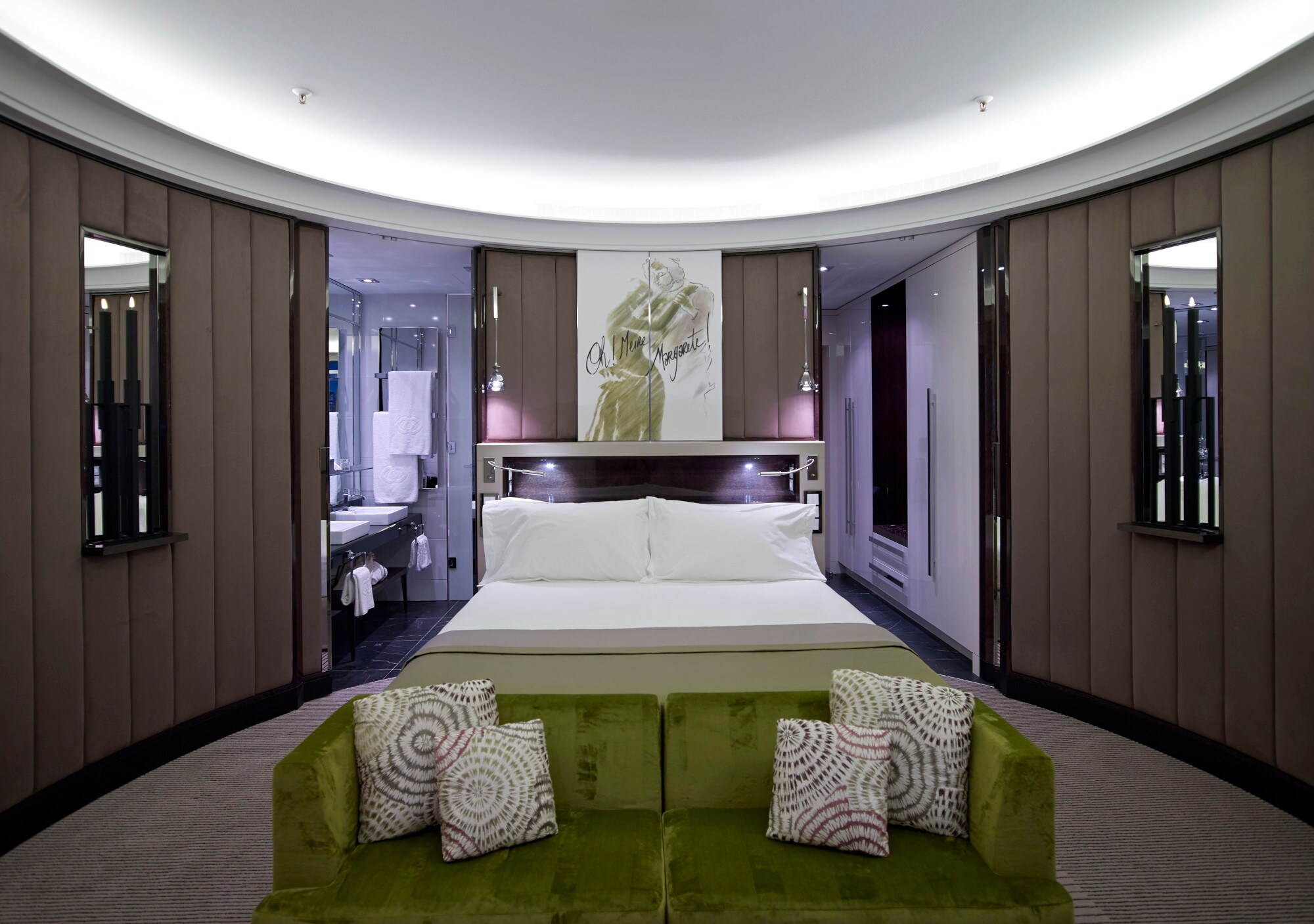 Eine moderne Hotelsuite mit runden Wänden und Doppelbett.