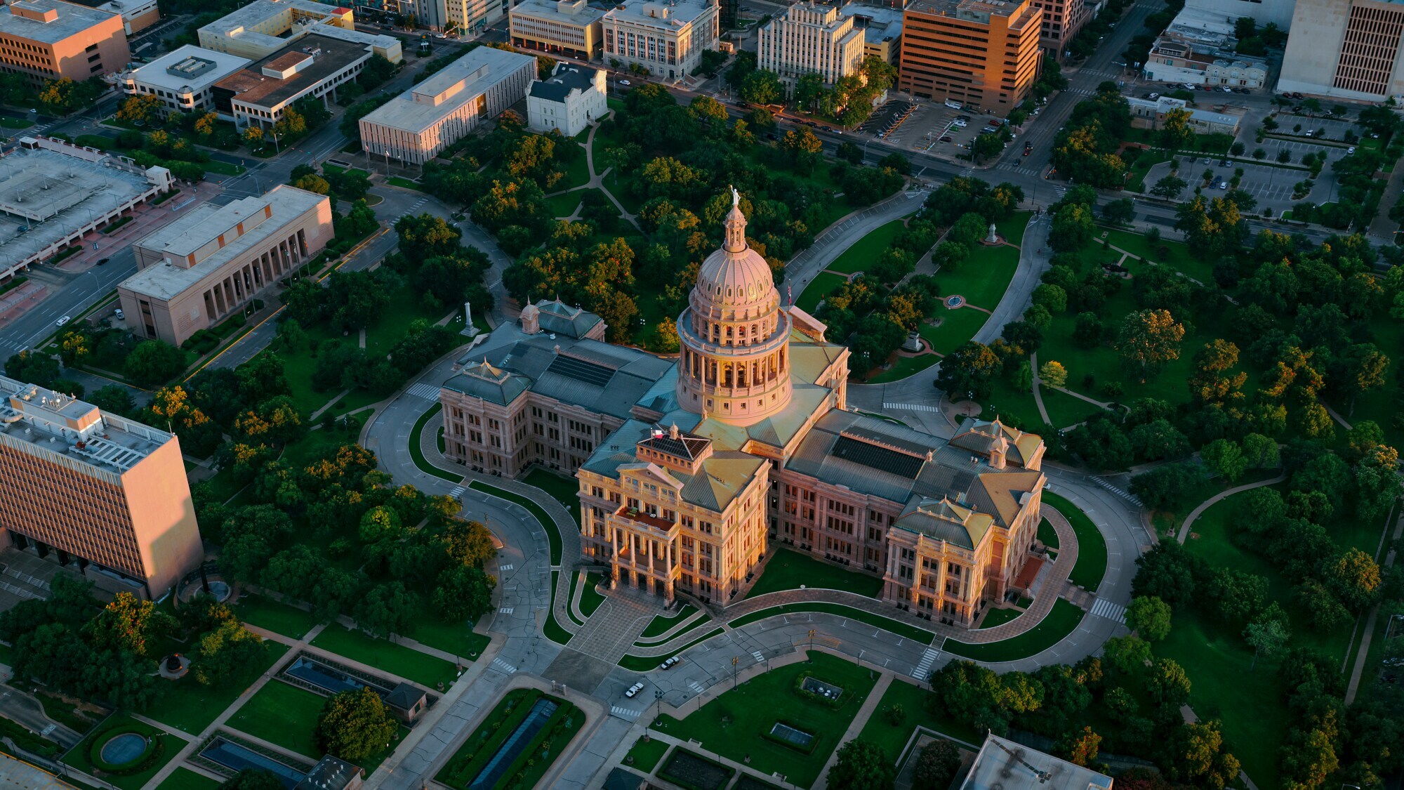 Luftaufnahme des Texas State Capitol, umgeben von einer Parklandschaft im Stadtzentrum Austins.