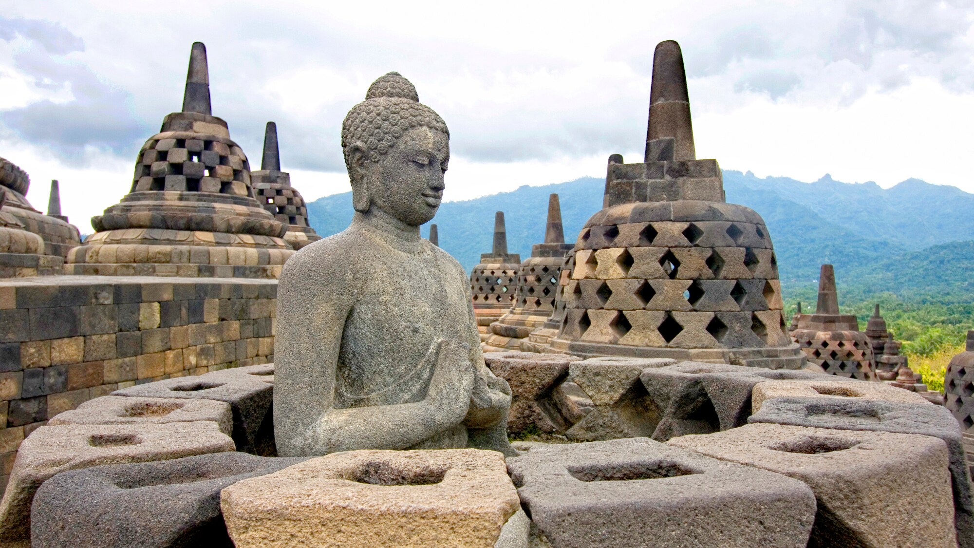 Buddhastatue und glockenförmige Gebilde der indonesischen Tempelanlage Borobudur. Buddhastatue und glockenförmige Gebilde der indonesischen Tempelanlage Borobudur.