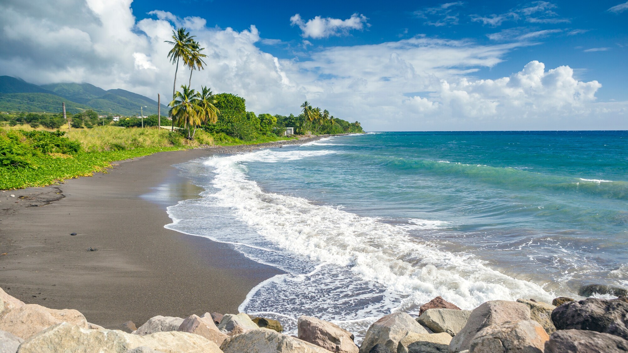 Ein schwarzer Sandstrand auf der Insel St. Kitts.