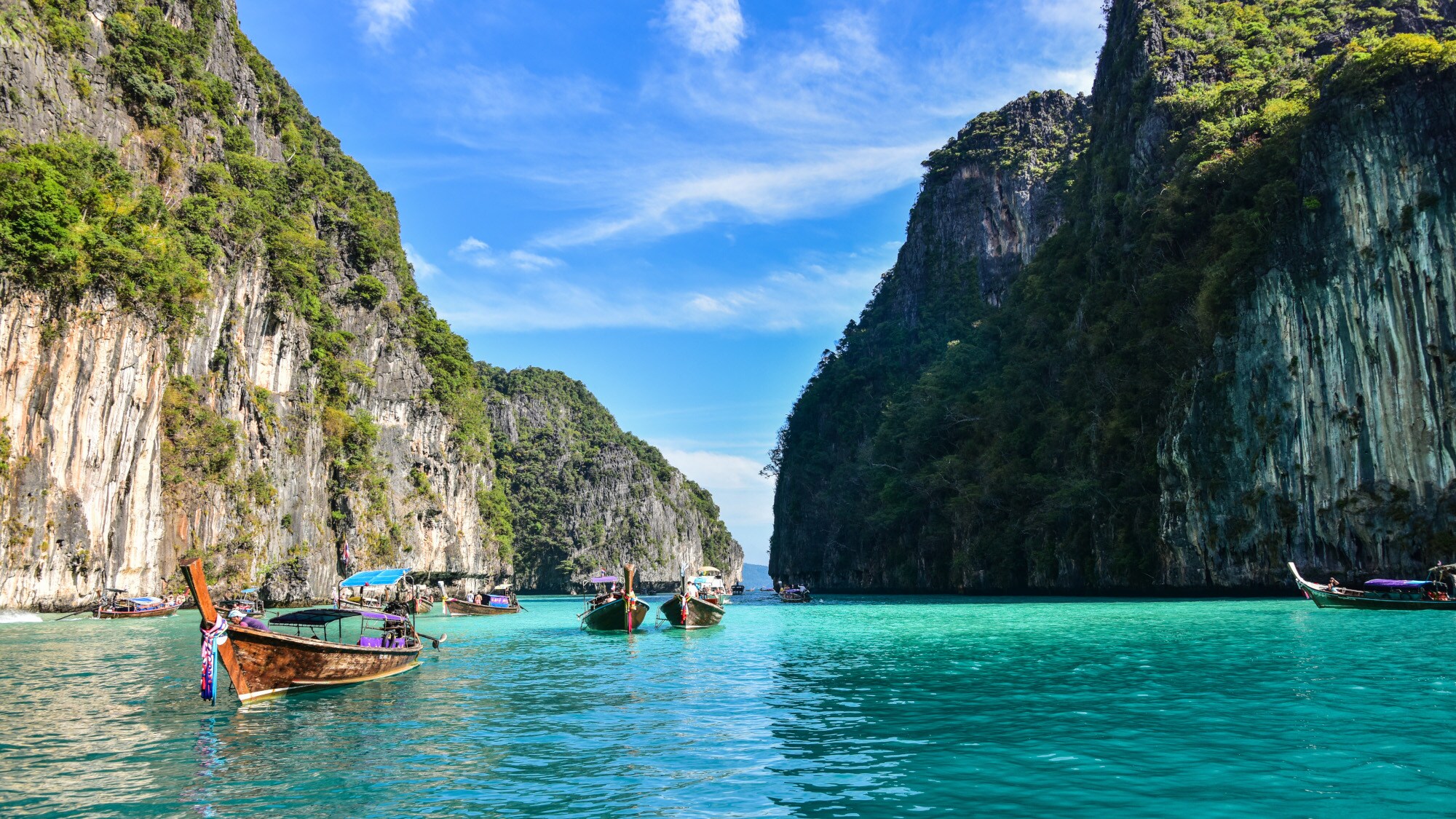 Boote in einer Lagune im türkisblauen Meer mit grün bewachsenen Felsen im Hintergrund. Boote in einer Lagune im türkisblauen Meer mit grün bewachsenen Felsen im Hintergrund.
