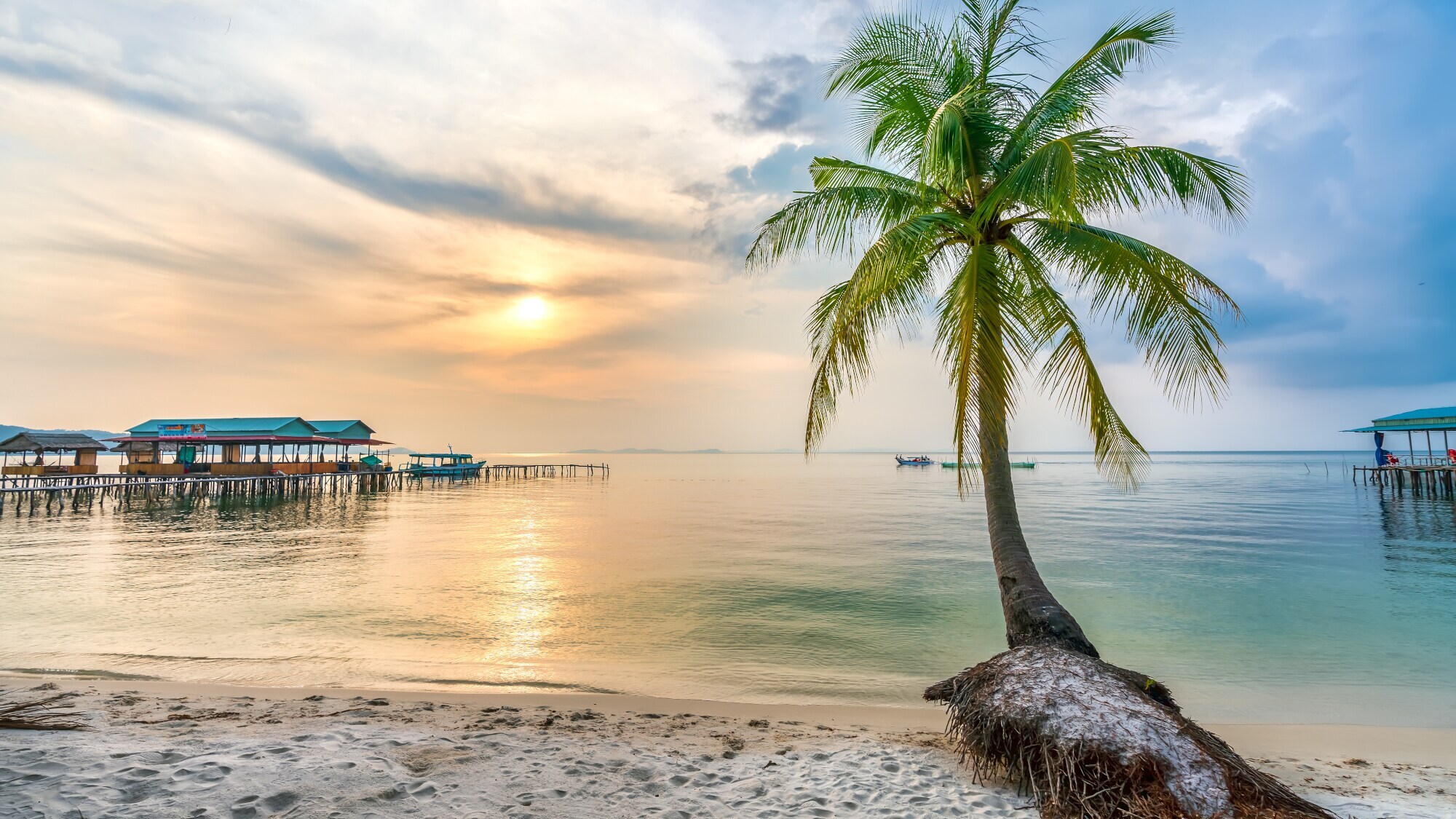 Strand bei Sonnenuntergang auf der vietnamesischen Insel Phu Quoc mit Palme im Vordergrund. Strand bei Sonnenuntergang auf der vietnamesischen Insel Phu Quoc mit Palme im Vordergrund.