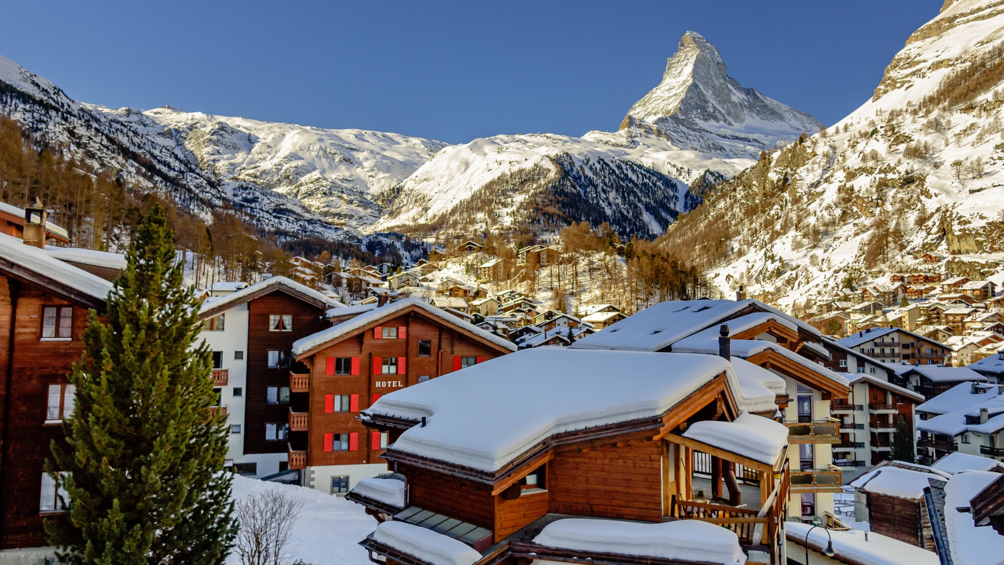 Verschneites Dorf Zermatt mit Matternhorn im Hintergrund.