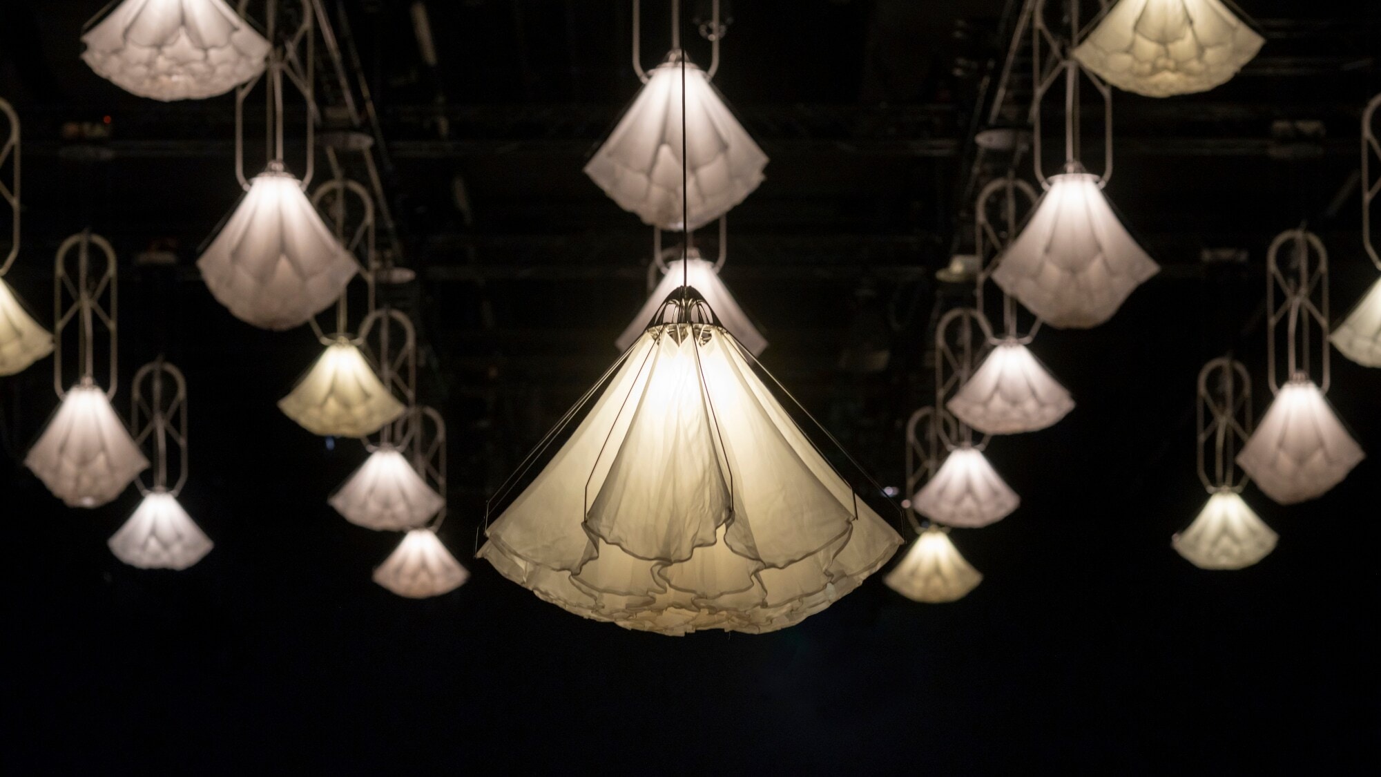 Blick von der Seite auf beleuchtete Seidenblüten, die unter einer Kuppel hängen Blick von der Seite auf beleuchtete Seidenblüten, die unter einer Kuppel hängen