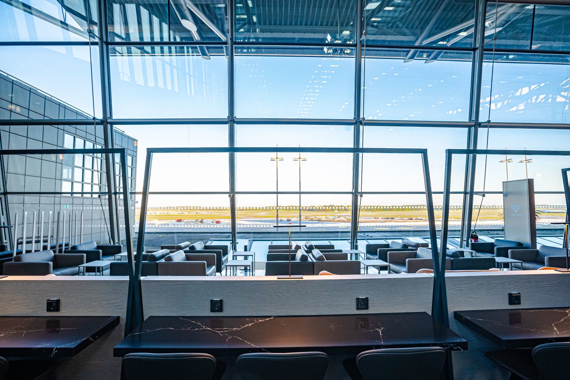 Leere Flughafen-Lounge mit Sitzmöbeln vor Panoramafenstern mit Blick aufs Rollfeld. Leere Flughafen-Lounge mit Sitzmöbeln vor Panoramafenstern mit Blick aufs Rollfeld.