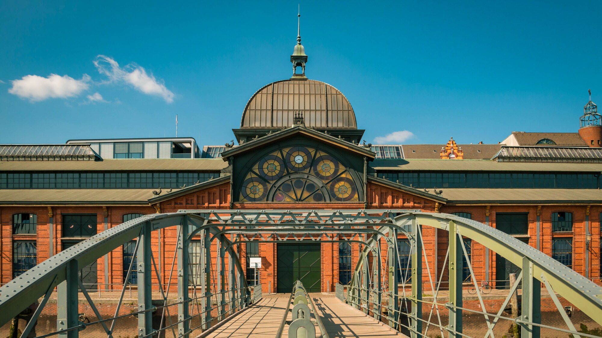 Fassade der Fischauktionshalle in Hamburg, zu dessen Backsteingebäude mit Kuppel und Fassadenverzierung eine Brücke führt. Fassade der Fischauktionshalle in Hamburg, zu dessen Backsteingebäude mit Kuppel und Fassadenverzierung eine Brücke führt.