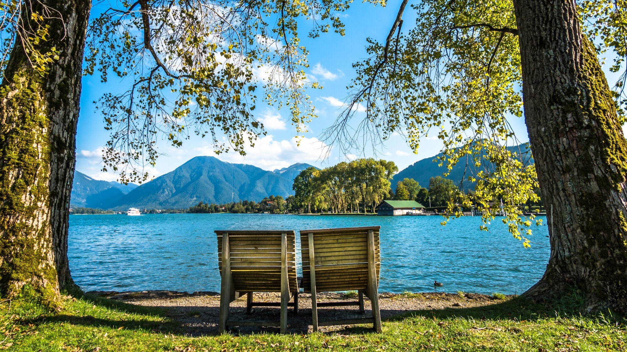 Zwei Holzliegen am Ufer des Tegernsees.
