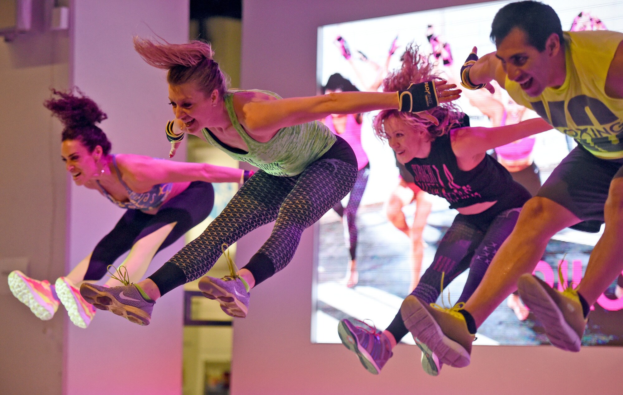 Vier Personen springen hoch und strecken dabei die Arme nach hinten und die Beine nach vorne.