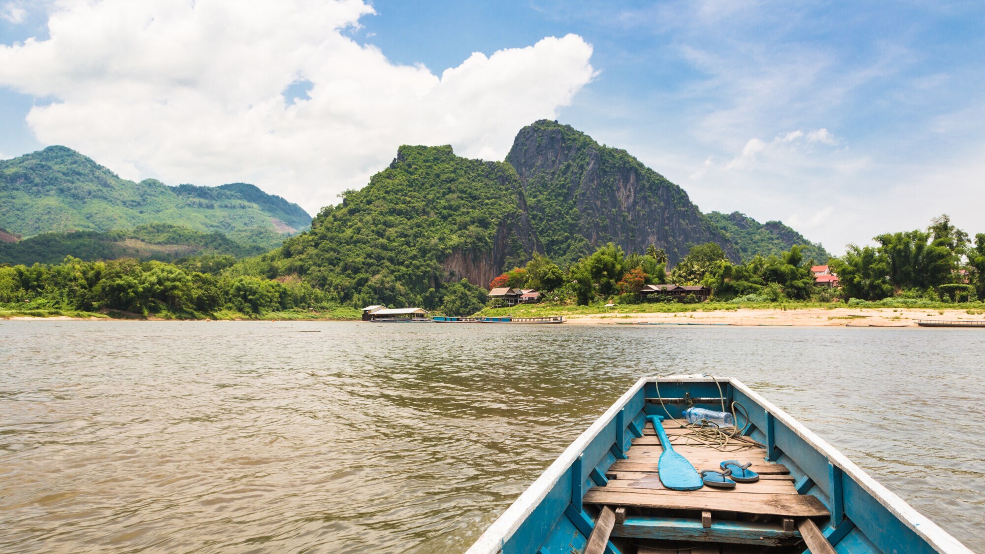 Holzboot am Ufer des Mekong, mit denen Touristen zur Pak-Ou-Höhle am anderen Ufer gebracht werden. In der Nähe von Luang Prabang, Laos.