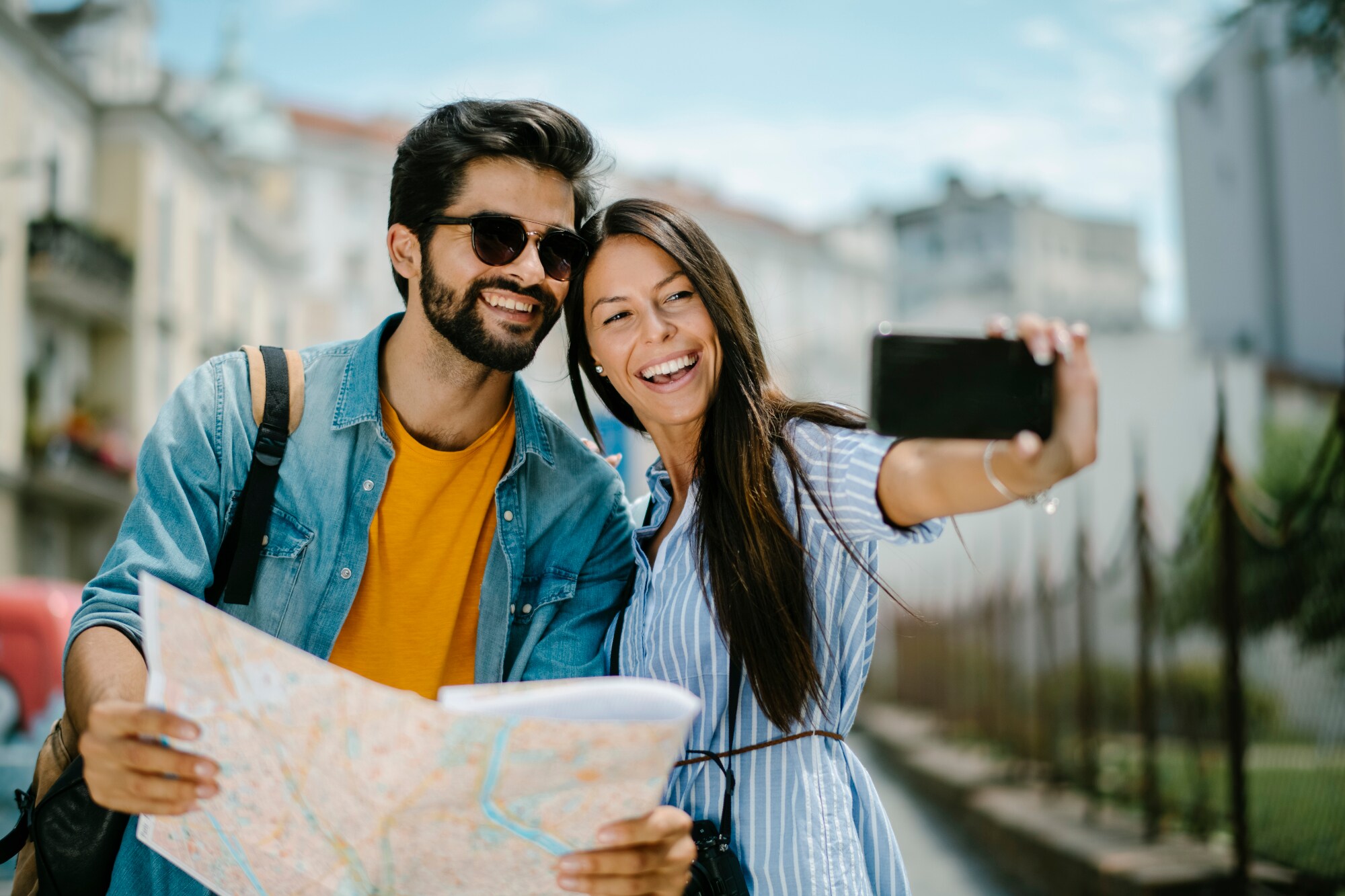 Ein fröhliches Paar mit Straßenplan beim Selfie fotografieren in urbaner Umgebung. Ein fröhliches Paar mit Straßenplan beim Selfie fotografieren in urbaner Umgebung.