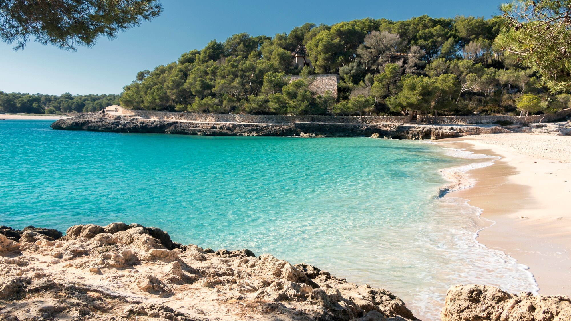 Eine menschenleere Bucht auf Mallorca mit Sandstrand und türkisblauem Wasser. Eine menschenleere Bucht auf Mallorca mit Sandstrand und türkisblauem Wasser.