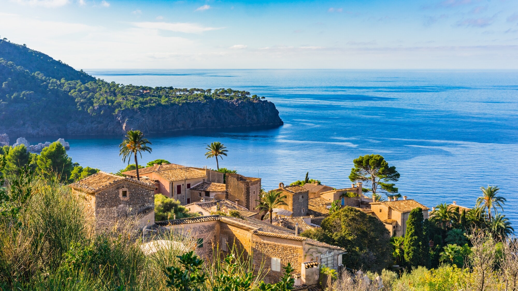 Ein altes Dorf an der Küste Mallorcas. Im Hintergrund eine grün überwachsene Landzunge, die in das Meer hineinragt. Ein altes Dorf an der Küste Mallorcas. Im Hintergrund eine grün überwachsene Landzunge, die in das Meer hineinragt.