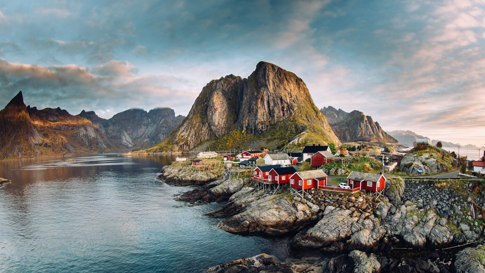 Luftansicht eines Fjords auf den Lofoten mit Felsen, roten Fischerhütten und Bergen. Luftansicht eines Fjords auf den Lofoten mit Felsen, roten Fischerhütten und Bergen.