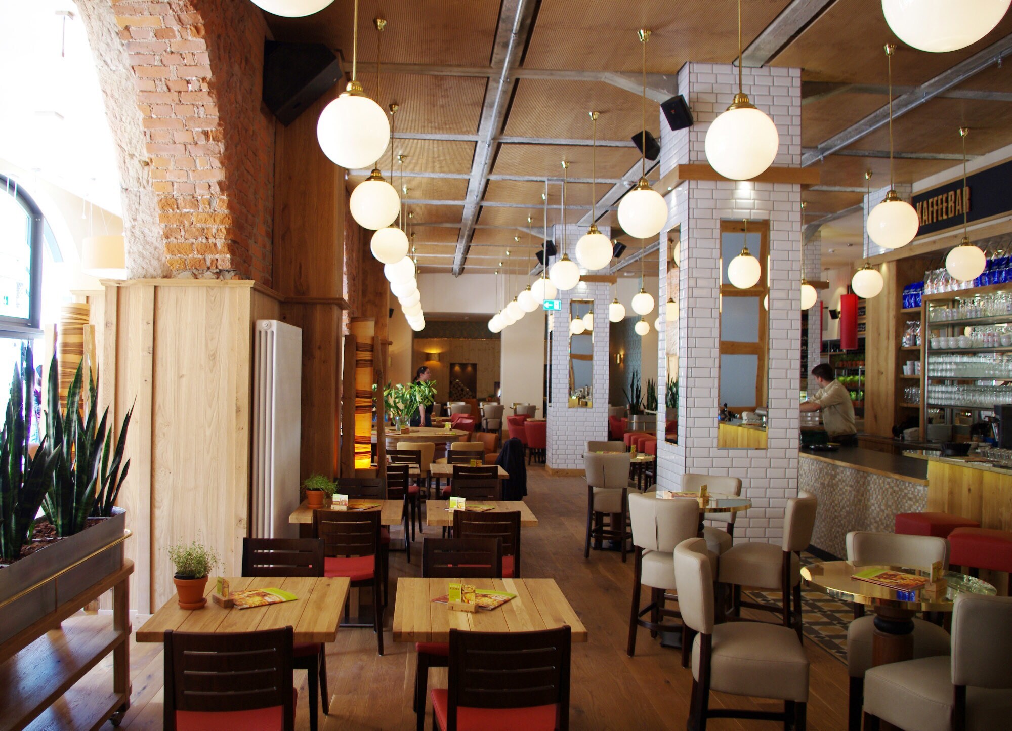 Modernes Bistro mit eklektischer Einrichtung in einem historischen Gebäude.