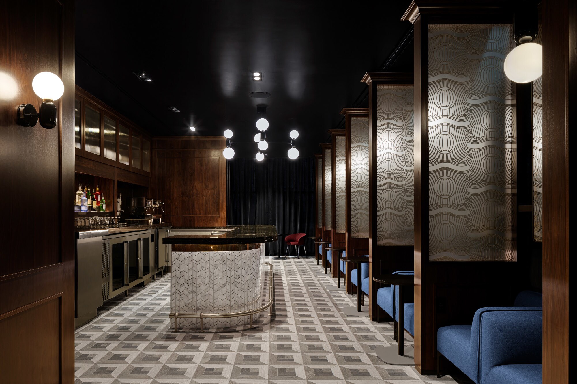 Eleganter Barbereich mit dunklen Holzelementen und blauen Sesseln.