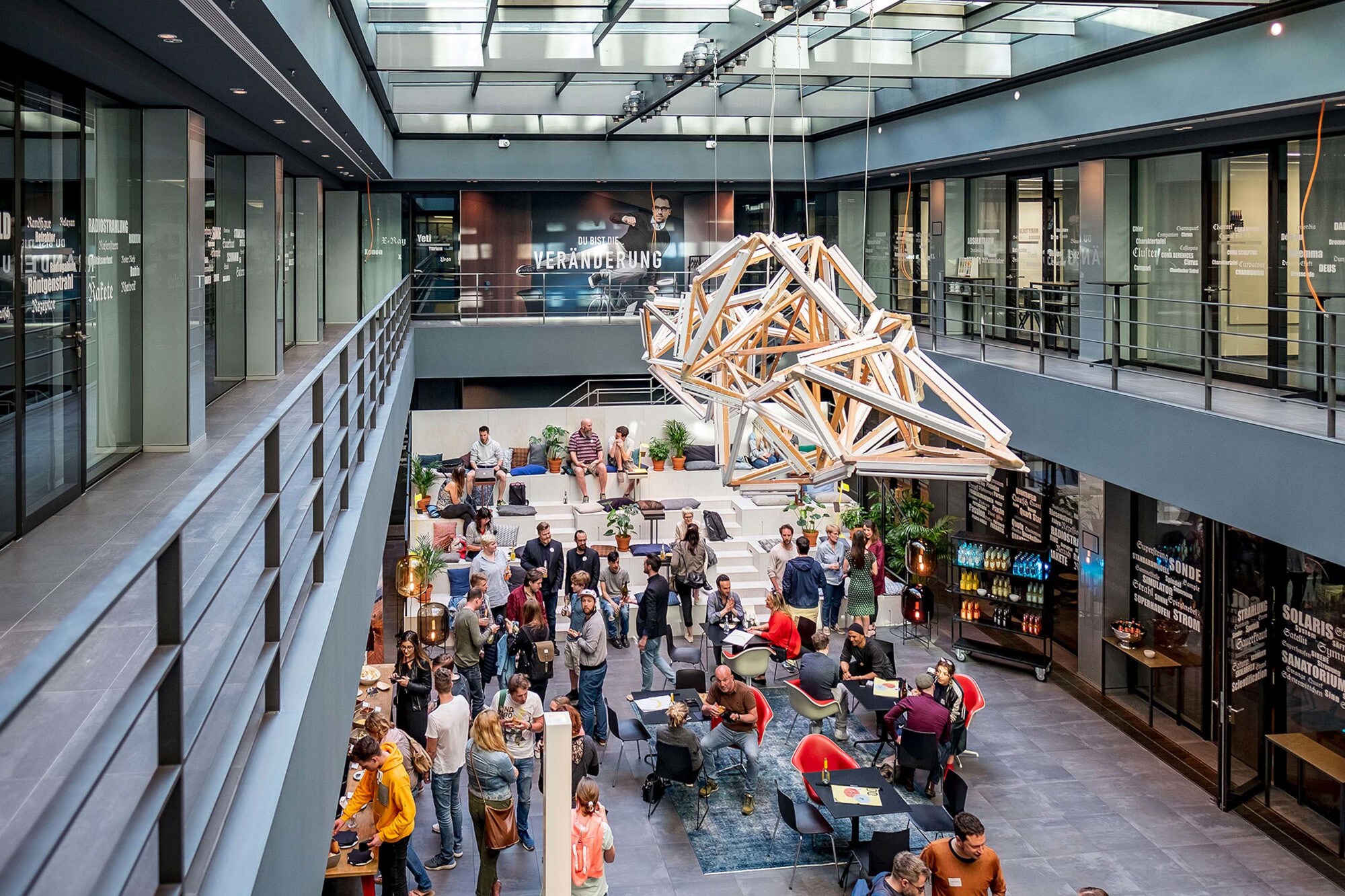 Personen bei einem Event in einem Innenhof eines Bürogebäudes. Personen bei einem Event in einem Innenhof eines Bürogebäudes.