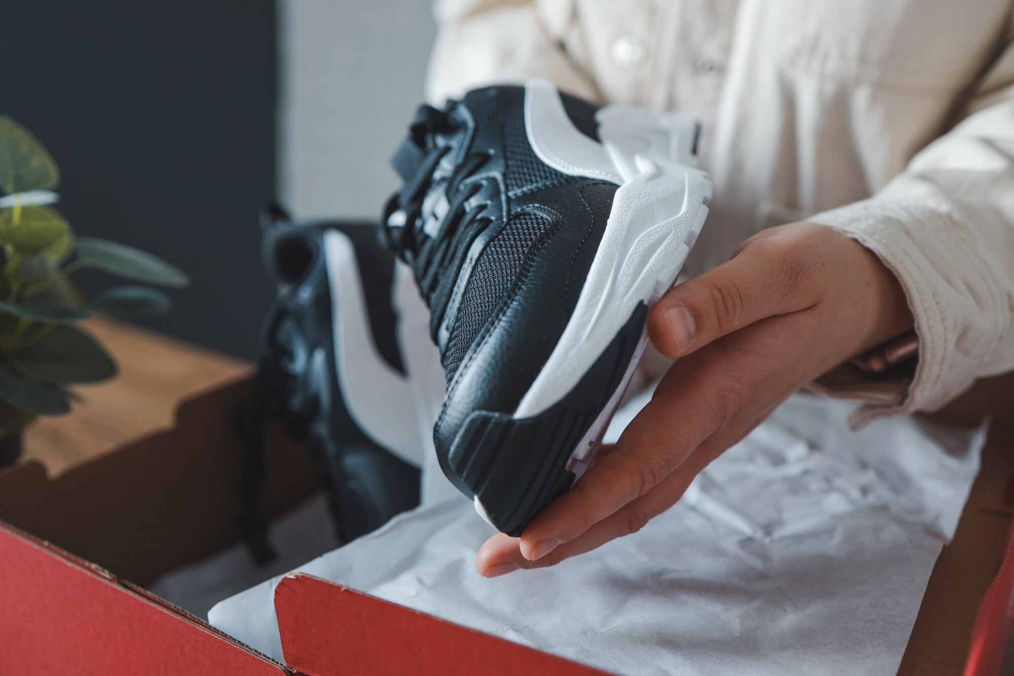 Unpacking women Eine Person packt neue Sneaker aus einem Schuhkarton.
