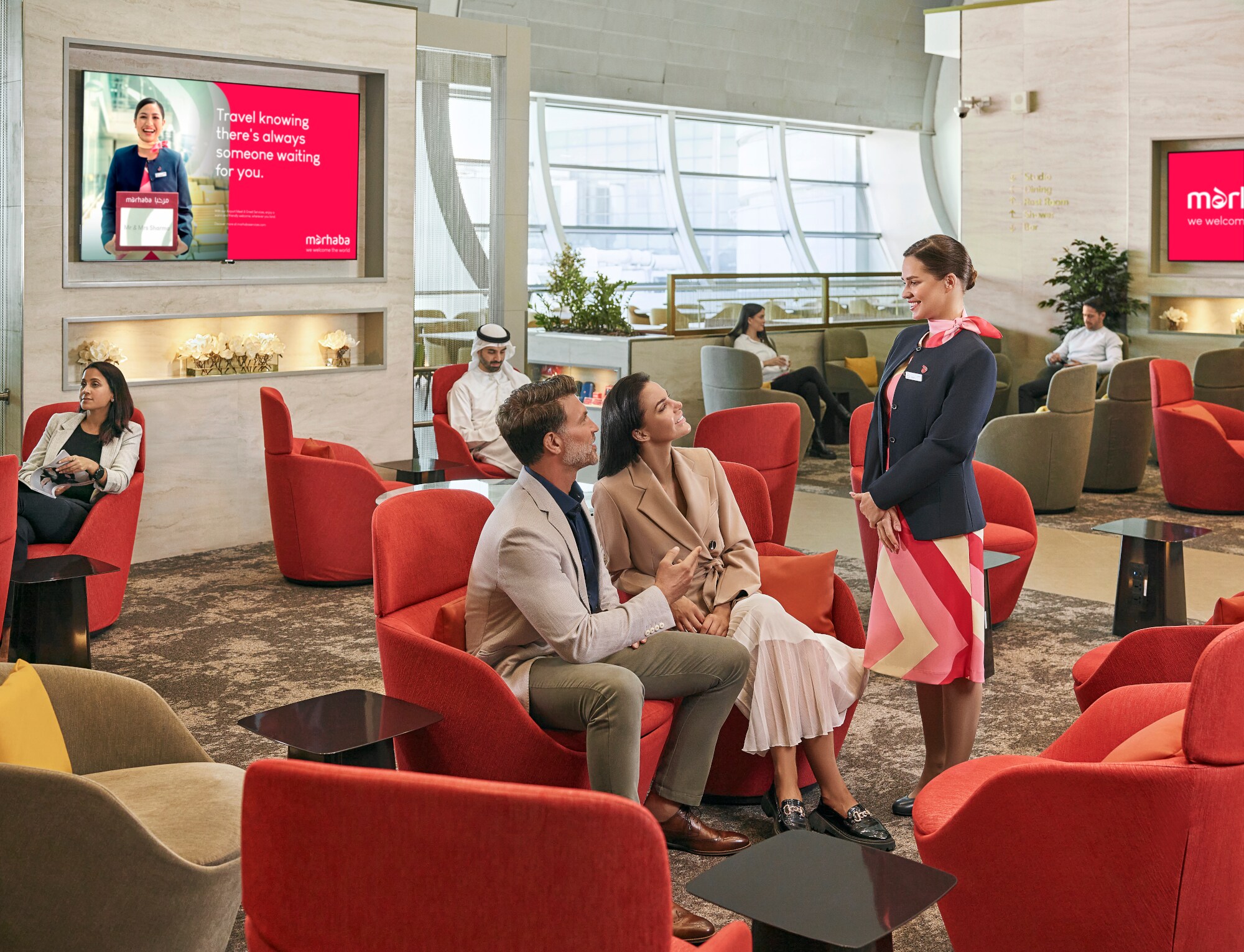 Mehrere Personen sitzen auf Polstermöbeln in einer modernen Flughafenlounge.