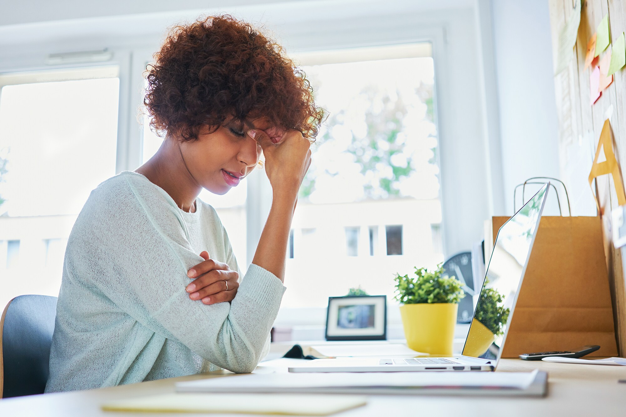 Fails im Office: 5 unangenehme Situationen, die jeder kennt Eine Frau am Schreibtisch fasst sich an die Stirn.