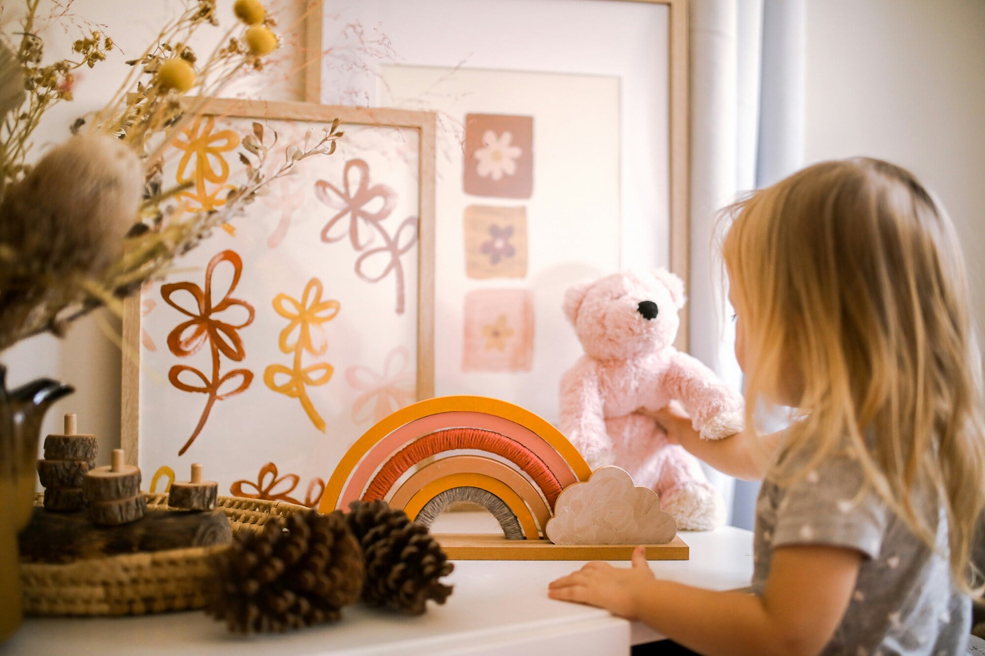 American Express Merchant Story „Frau Nellson und ihre Schönigkeiten“ Ein kleines Kind spielt mit einem Teddy und mit Holzspielzeug.