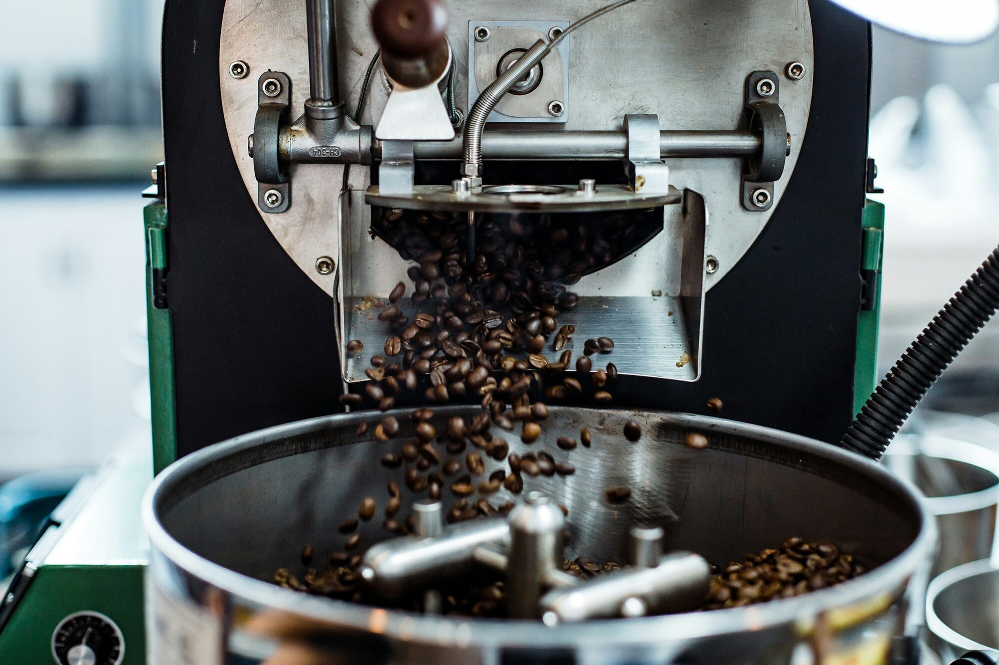 American Express Merchant Story „Roastmarket" Das Foto zeigt einen Kaffeeröster in Betrieb.
