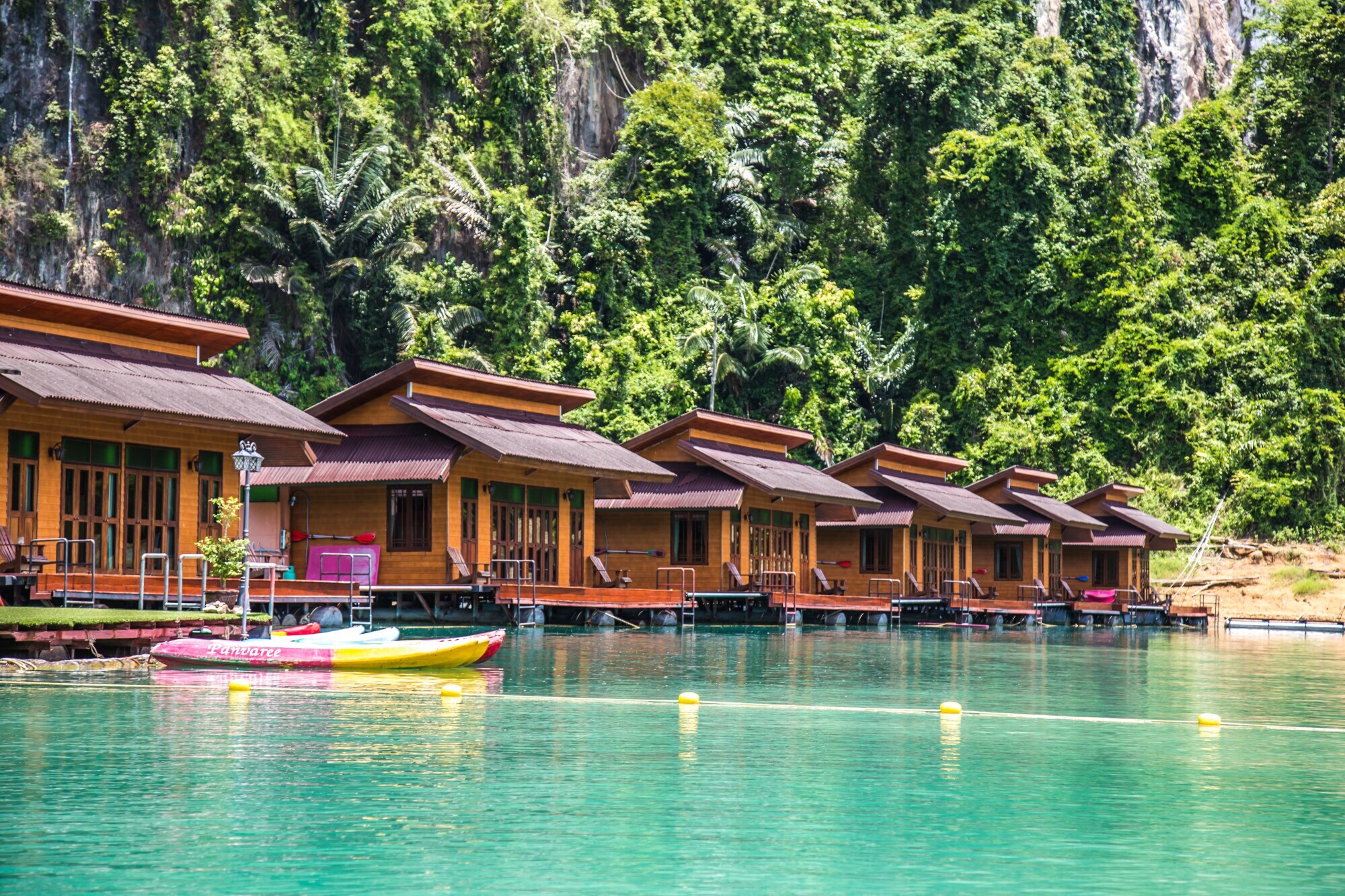 Mehrere hölzerne Floating Bungalows nebeneinander auf dem türkisfarbenen Chiao-Lan-See Mehrere hölzerne Floating Bungalows nebeneinander auf dem türkisfarbenen Chiao-Lan-See